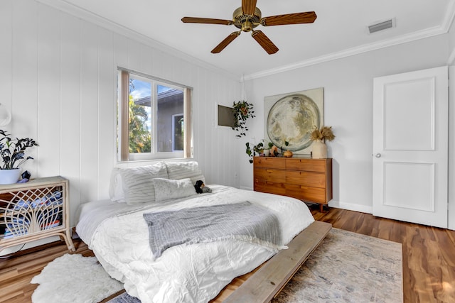 bedroom featuring ceiling fan, ornamental molding, and dark hardwood / wood-style floors