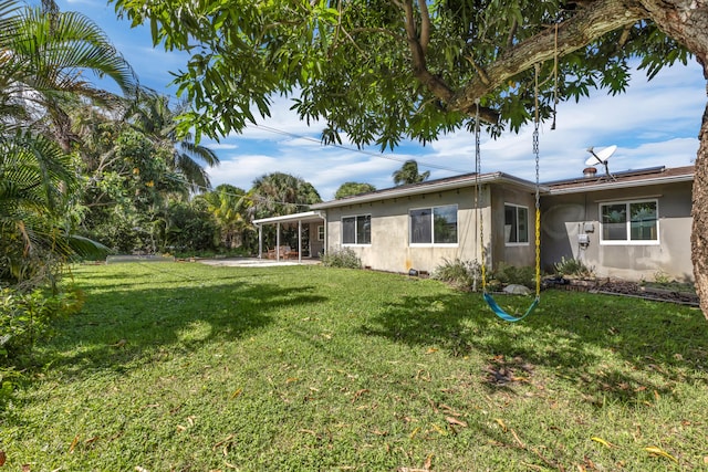 rear view of property featuring a lawn