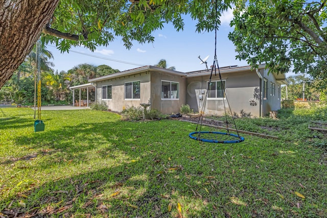 back of house featuring a patio area and a lawn