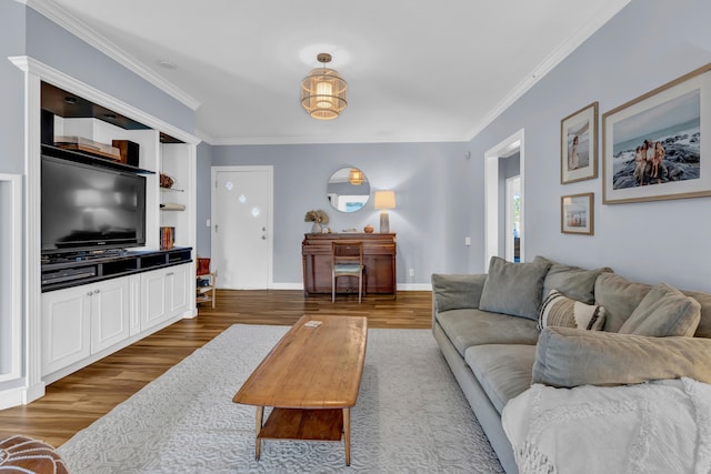 living room with ornamental molding, hardwood / wood-style floors, and built in shelves