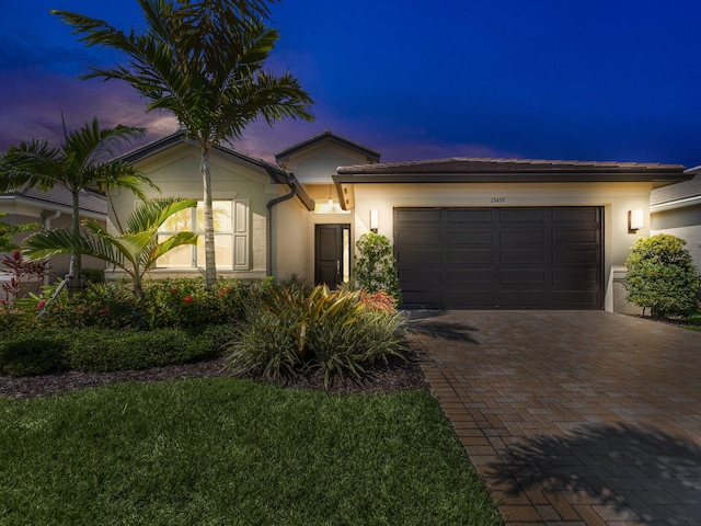 view of front of home with a garage and a lawn