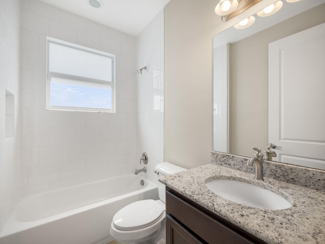 full bathroom featuring toilet, tiled shower / bath, and vanity