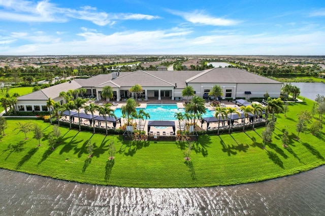 view of pool with a patio, a yard, and a water view