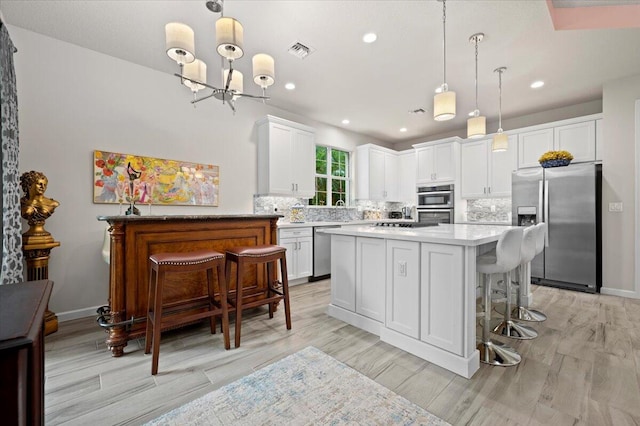 kitchen featuring appliances with stainless steel finishes, pendant lighting, and a kitchen island