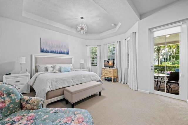 bedroom featuring access to outside, light carpet, a raised ceiling, a chandelier, and a textured ceiling