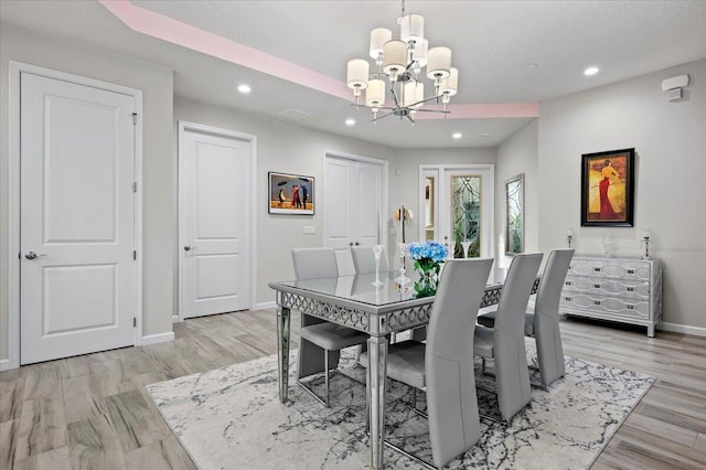 dining area with a chandelier and light wood-type flooring