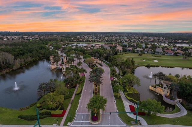 aerial view at dusk featuring a water view