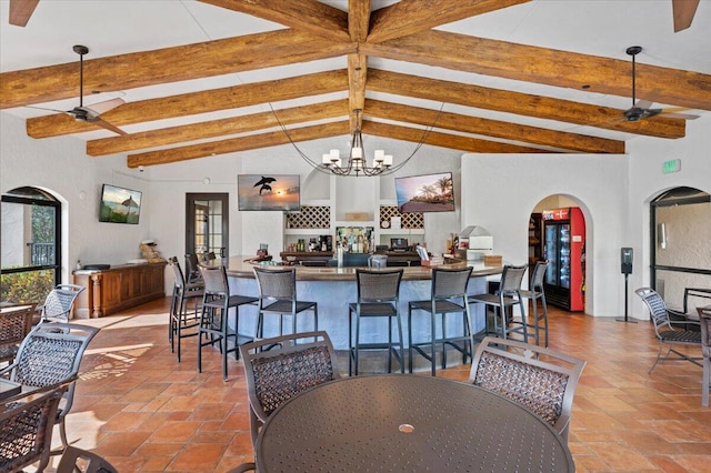 kitchen featuring vaulted ceiling with beams, a kitchen breakfast bar, hanging light fixtures, and ceiling fan with notable chandelier