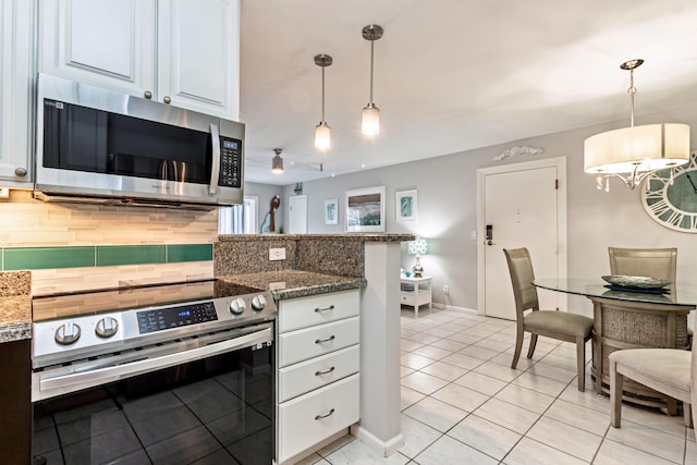 kitchen featuring hanging light fixtures, appliances with stainless steel finishes, backsplash, and white cabinetry