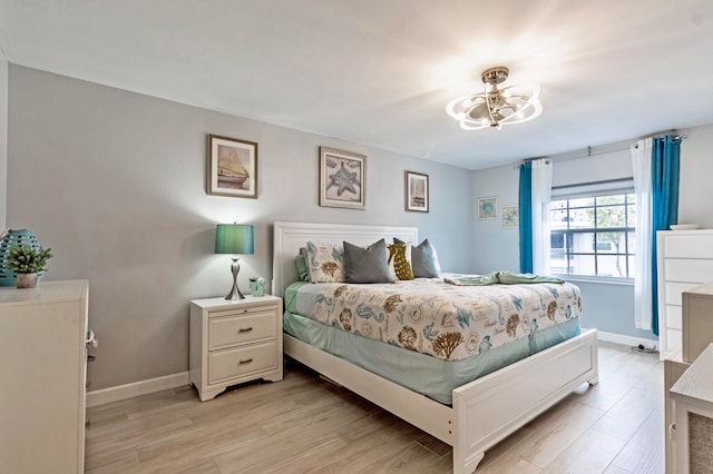 bedroom featuring a chandelier and light hardwood / wood-style flooring