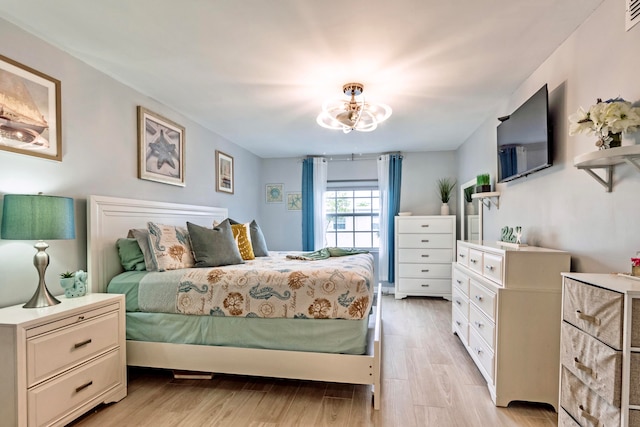 bedroom with a chandelier and light hardwood / wood-style floors