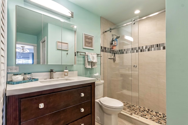 bathroom featuring vanity, toilet, and a shower with door