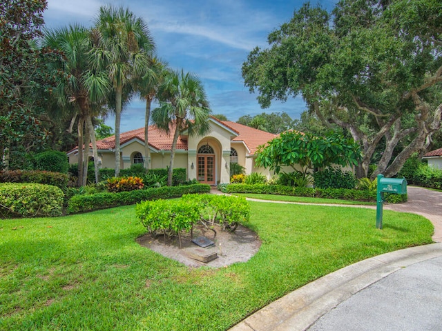 mediterranean / spanish-style house with a front yard