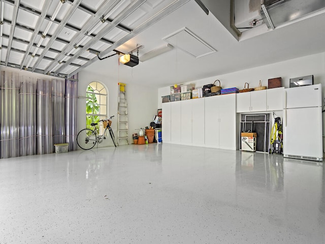 garage featuring a garage door opener and white fridge