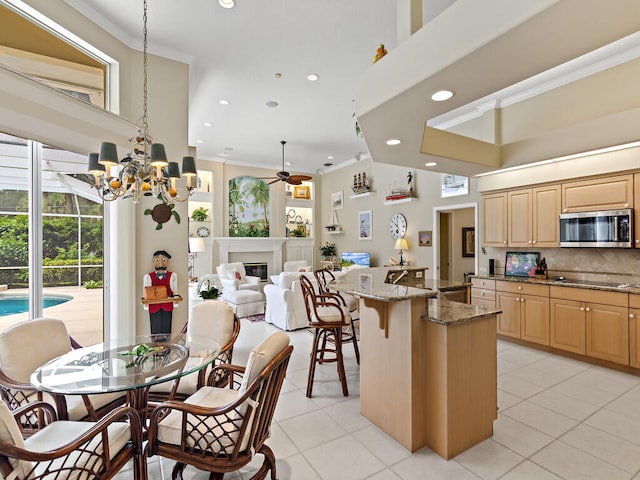 kitchen featuring light stone counters, decorative backsplash, ornamental molding, a kitchen bar, and a center island