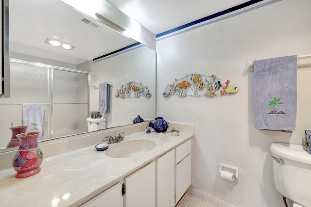 bathroom featuring vanity, toilet, tile patterned flooring, and an enclosed shower