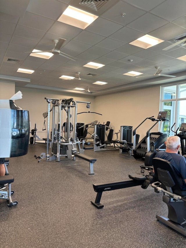 exercise room featuring a paneled ceiling and ceiling fan