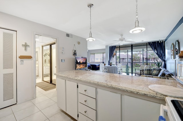 kitchen featuring ceiling fan, decorative light fixtures, light tile patterned floors, and white cabinets