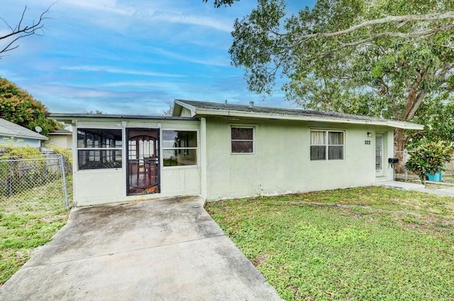 view of front facade featuring a sunroom and a front yard