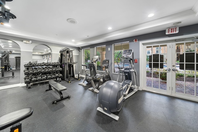 gym with french doors, a tray ceiling, and ornamental molding