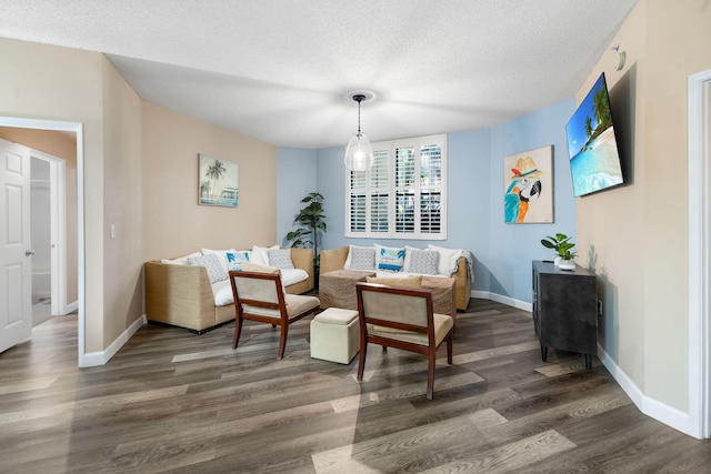 living area featuring dark wood-type flooring and a textured ceiling