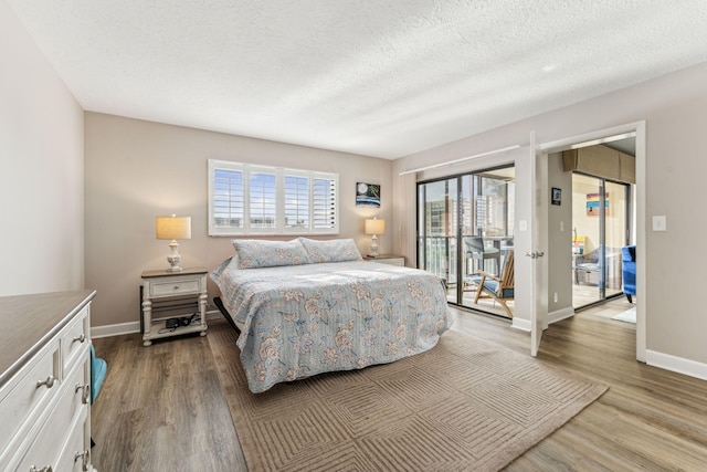 bedroom with a textured ceiling, light wood-type flooring, and access to exterior