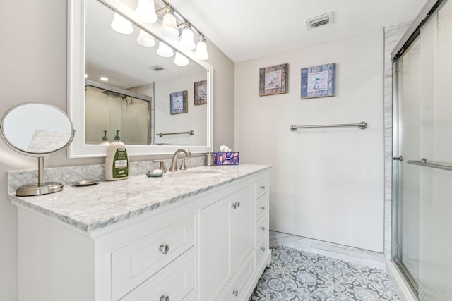 bathroom with vanity, a shower with shower door, and tile patterned floors