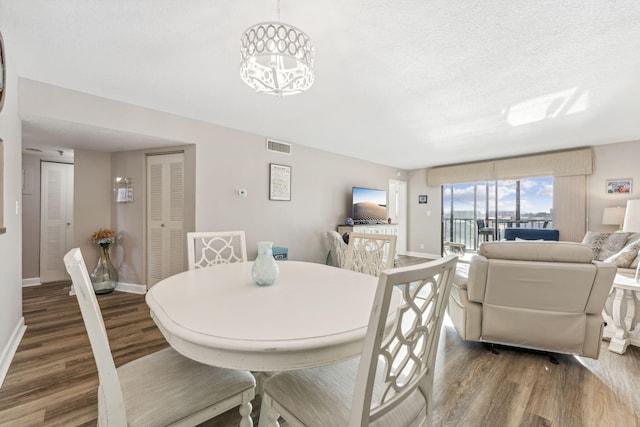 dining space featuring a textured ceiling and dark hardwood / wood-style flooring