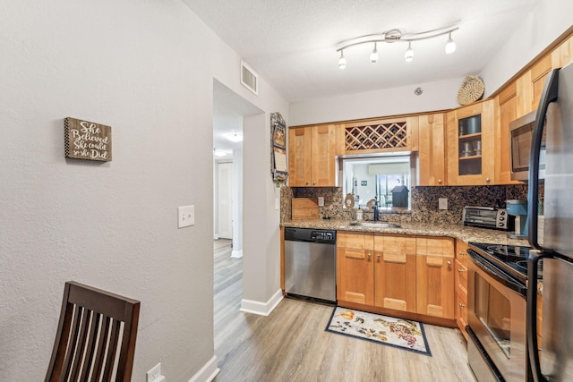 kitchen featuring dishwasher, sink, black electric range, light stone counters, and tasteful backsplash