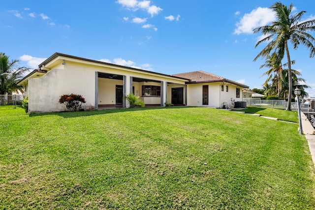 view of front of home featuring a front lawn and central AC