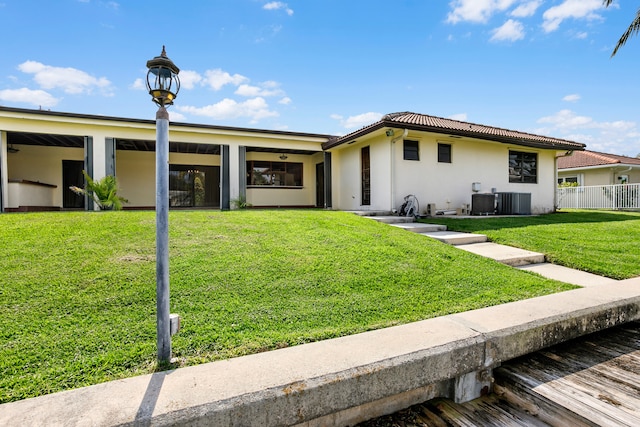 view of front facade with a front yard and cooling unit