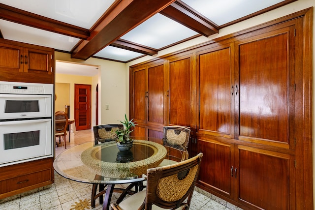 dining space featuring beamed ceiling