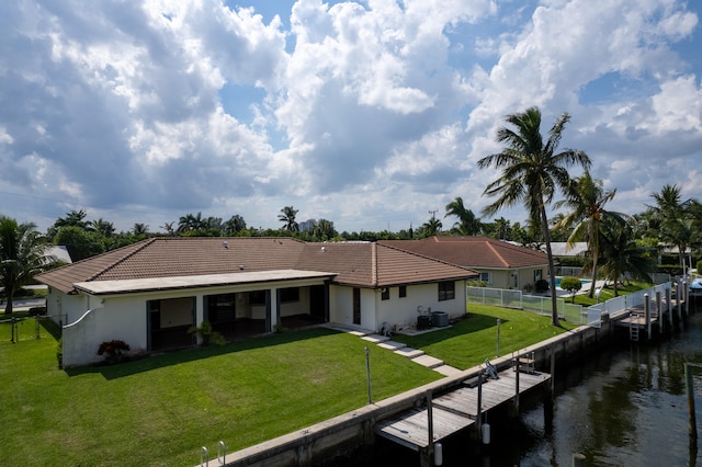 back of property featuring a water view and a lawn