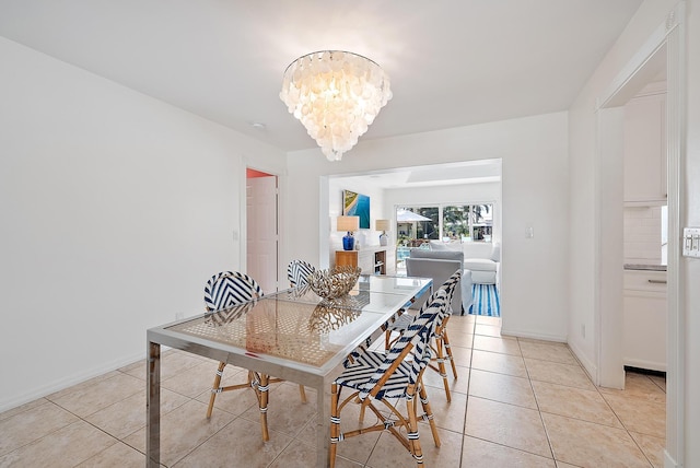 tiled dining room with an inviting chandelier