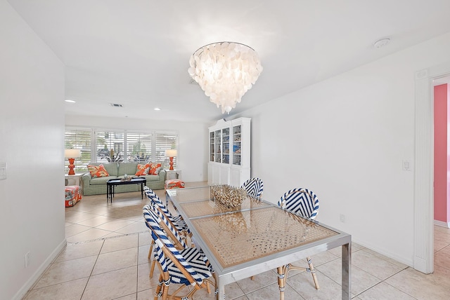 dining area featuring light tile patterned flooring and a chandelier