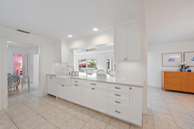 kitchen featuring white cabinets, light stone countertops, ceiling fan, and light tile patterned floors