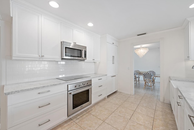 kitchen with backsplash, white cabinetry, stainless steel appliances, light stone counters, and light tile patterned floors