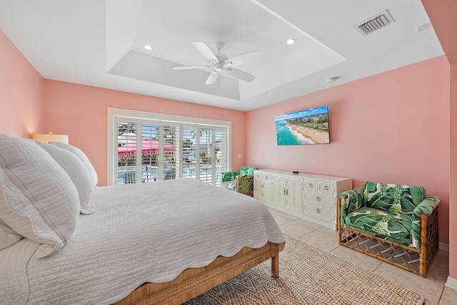 tiled bedroom with a raised ceiling, access to exterior, and ceiling fan