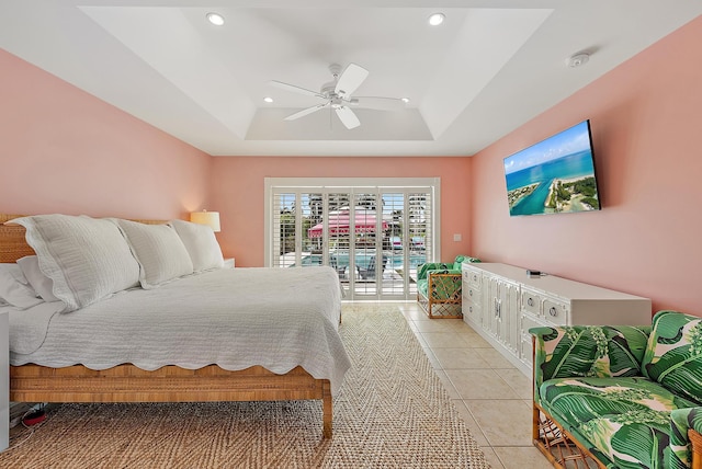 bedroom with access to exterior, light tile patterned floors, a tray ceiling, and ceiling fan