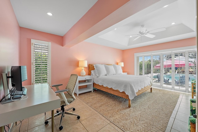 tiled bedroom with multiple windows, access to exterior, a raised ceiling, and ceiling fan