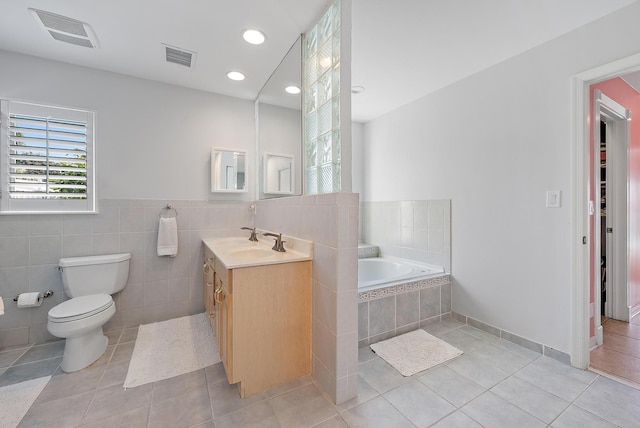 bathroom featuring vanity, tile patterned flooring, toilet, and a washtub