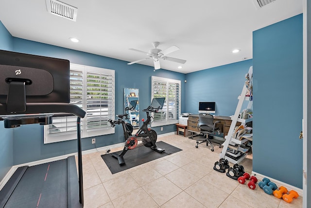 exercise room featuring a wealth of natural light, ceiling fan, and light tile patterned floors