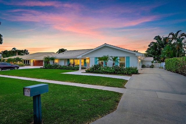 single story home featuring a yard and a garage