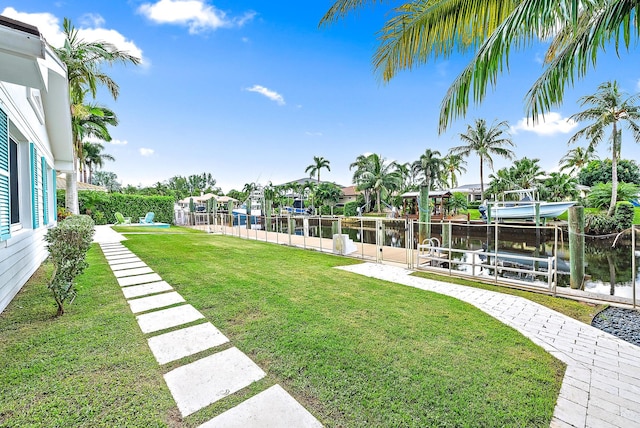 view of yard with a water view and a boat dock