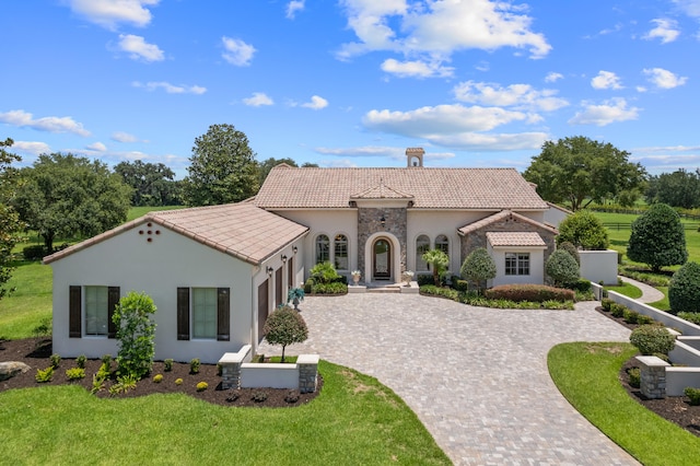 mediterranean / spanish home with a front yard