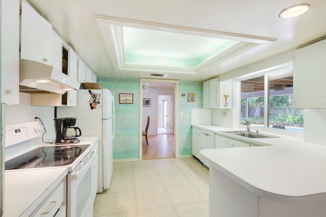 kitchen featuring sink, white cabinets, white appliances, and a raised ceiling