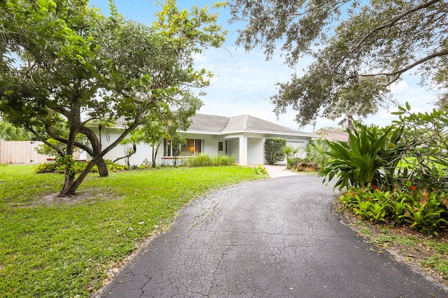 single story home featuring a front yard and a garage