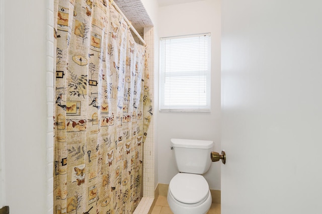 bathroom featuring toilet, a shower with shower curtain, and tile patterned flooring