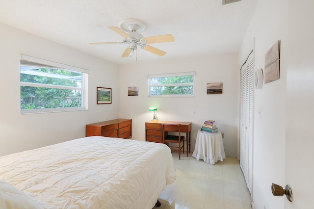 bedroom with multiple windows, a closet, and ceiling fan