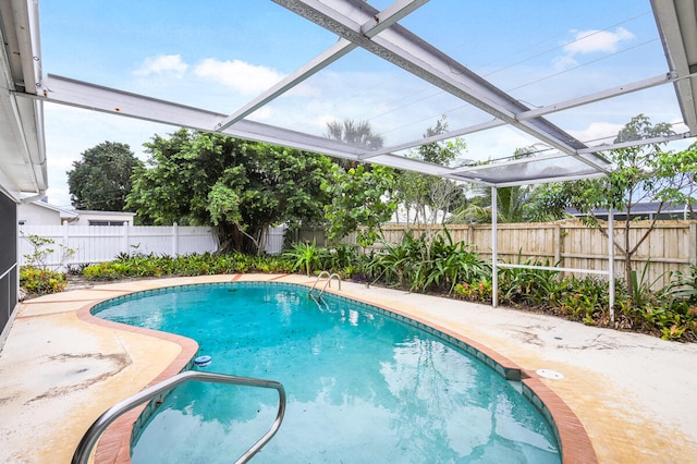 view of swimming pool featuring a patio and a lanai